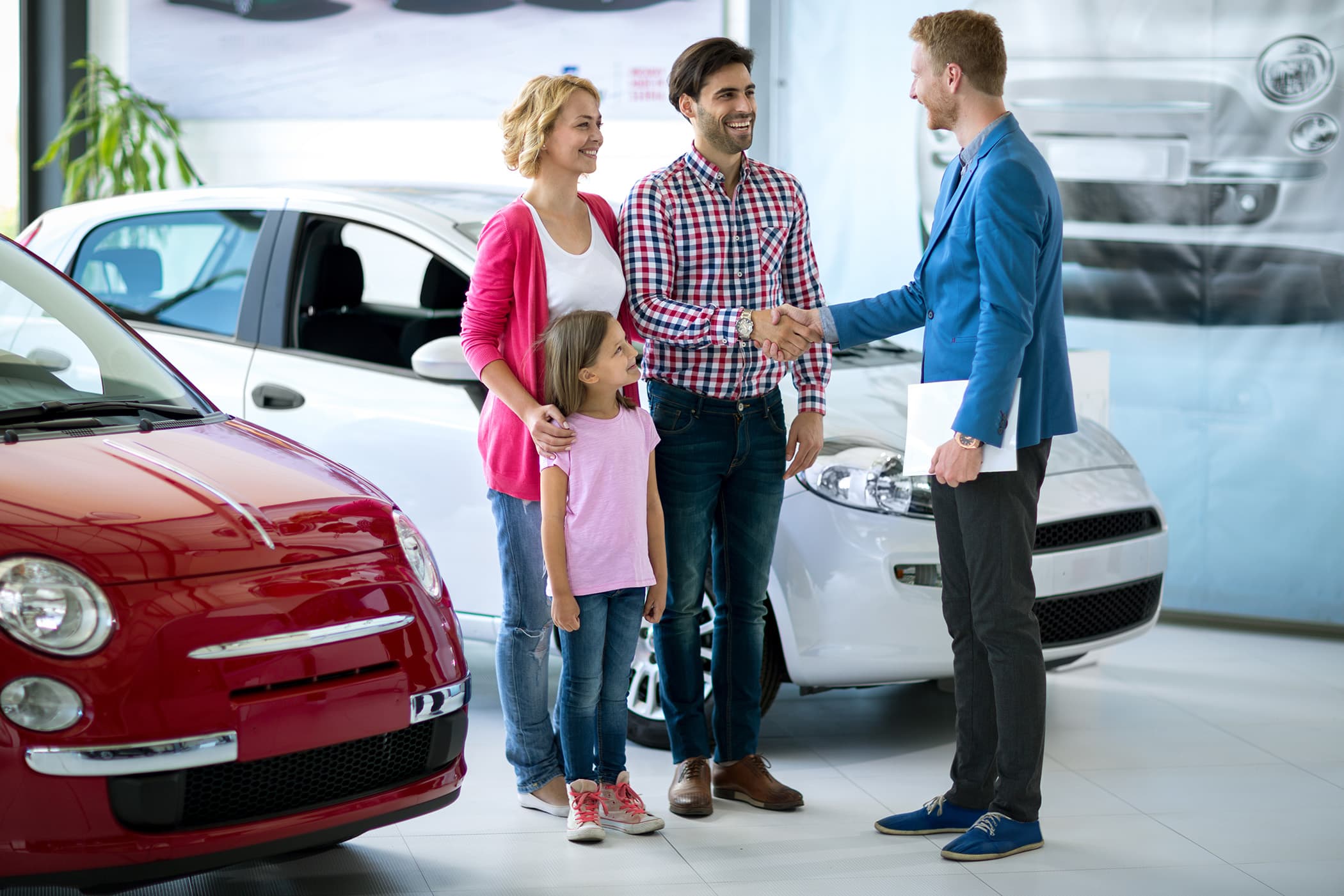 Image of a sales person, helping a customer at the dealership with signing a contract for a vehicle.