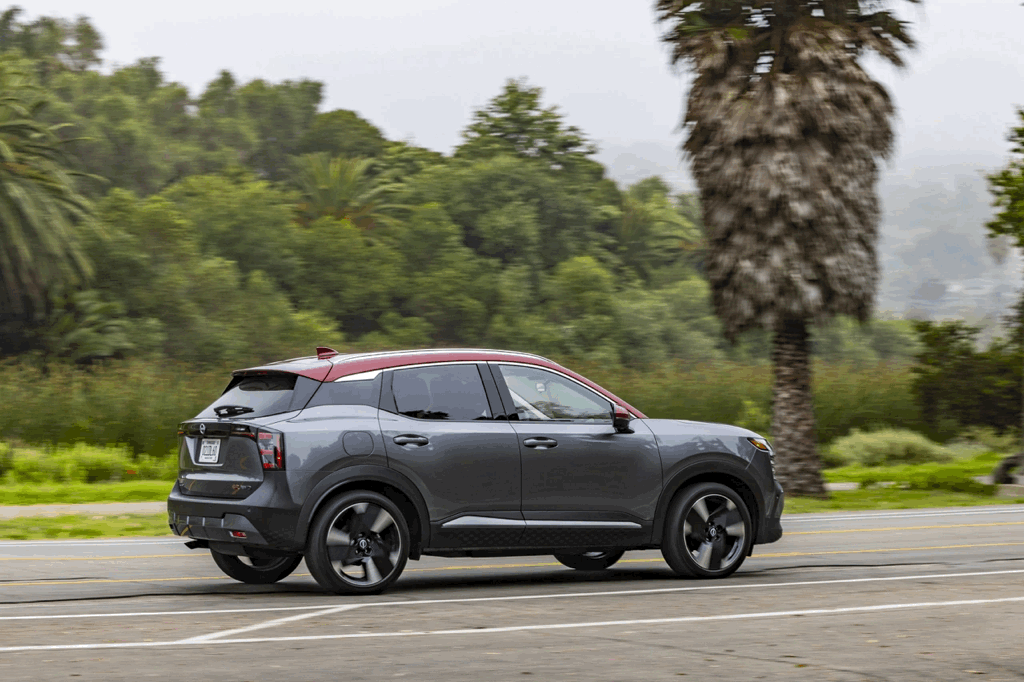 Grey 2026 Nissan Kicks in profile on the road, spec sheet of the subcompact SUV.