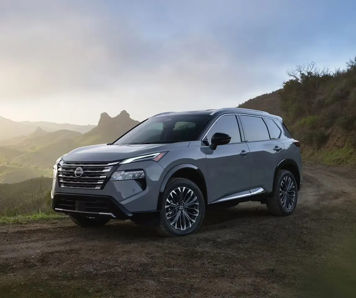 Grey 2026 Nissan Rogue on a scenic road summarizing gasoline and hybrid trims.