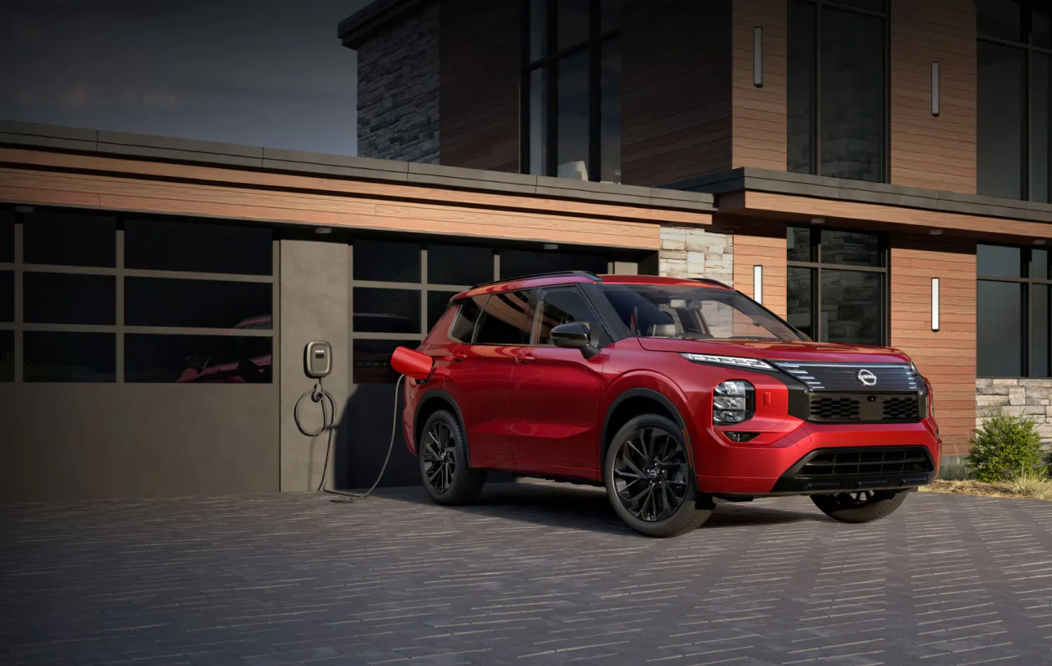 Red 2026 Nissan Rogue plug-in hybrid plugged in front of a modern home.