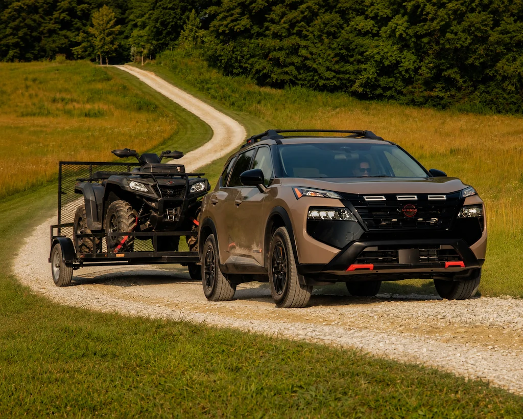 2026 Nissan Rogue Rock Creek towing an ATV to illustrate towing capacity.