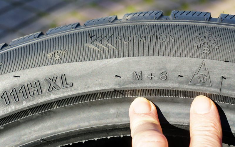 Markings on the sidewall of a new winter tire, speed, load, rotation, mud and snow designations